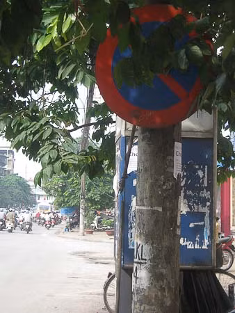 Tấm biển báo hiệu núp dưới lùm cây này liệu người dân đi đường có nhìn thấy ( ảnh chụp trên đường Phạm Ngọc Thạch )