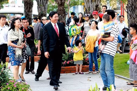 Ông nở nụ cười với một em nhỏ được bố bế trên tay