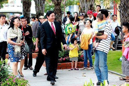 Ông nở nụ cười với một em nhỏ được bố bế trên tay Ông nở nụ cười với một em nhỏ được bố bế trên tay