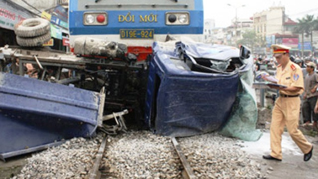 Chiếc ô tô 16 chỗ bị đoàn tàu SP4 tông nát rạng sáng ngày 3/2 (Ảnh Lan Hương)