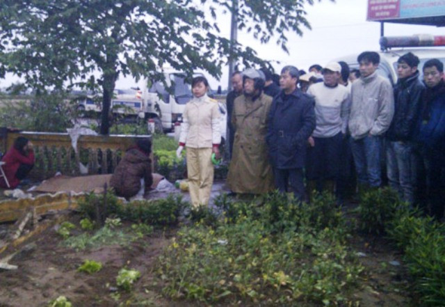 Người thân tài xế ôtô tử vong than khóc bên xác nạn nhân. Vụ tai nạn thu hút hàng trăm người dân (Ảnh Hùng Khoa - Vnexpress))