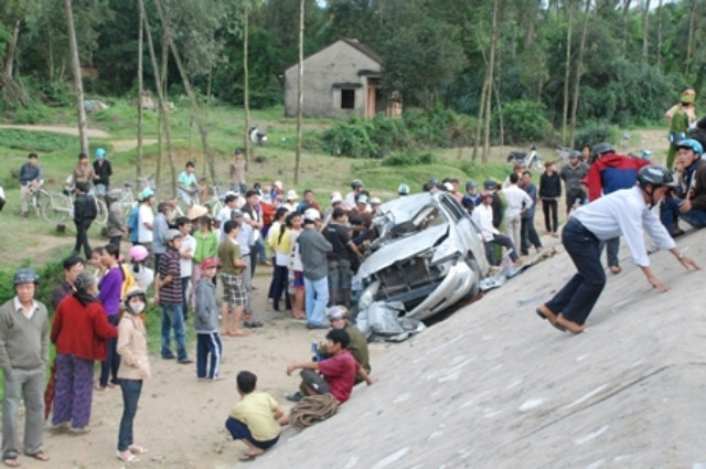 Sau cú va chạm với tàu hỏa, chiếc xe khách đâm vào rào chắn rồi rơi xuống vực ven đường (Ảnh VTC)