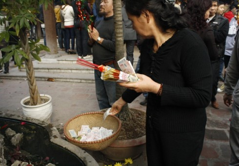 Ở chùa Hà (Cầu Giấy), người ta đặt tiền bất cứ đâu: trên cây, hòn non bộ, ném xuống ao… vì thế nhà chùa phải huy động cả những chiếc rổ đặt tại một số điểm ở sân chùa. Ảnh chụp chiều 16 tháng Giêng âm lịch. Ở chùa Hà (Cầu Giấy), người ta đặt tiền bất cứ đâu: trên cây, hòn non bộ, ném xuống ao… vì thế nhà chùa phải huy động cả những chiếc rổ đặt tại một số điểm ở sân chùa. Ảnh chụp chiều 16 tháng Giêng âm lịch.