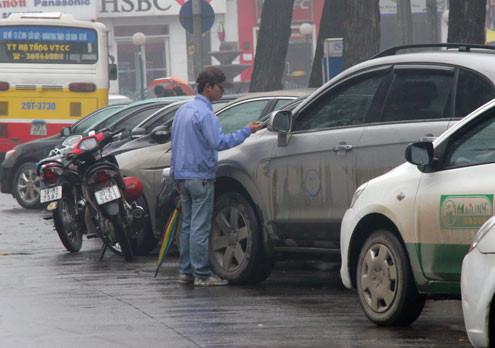 Nhân viên trông xe ở bãi đỗ sát hồ Gươm vẫn ra thu tiền của khách với mức phí 50.000 đồng một lượt.