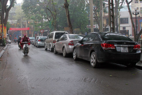 Cạnh đó, trên phố Nhà Chung, dù tấm biển đỗ xe được rút đi nhưng ôtô vẫn đậu thành hãng và nhân viên vẫn tới thu tiền.