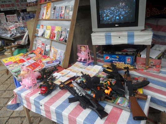 Dọc hai bên đường lên động Hương Tích, các loại đồ chơi bạo lực được bày hẳn ra bàn và theo như lời của các chủ cửa hàng kinh doanh thì mỗi khẩu súng bắn đạn nhựa này có xuất xứ từ Trung Quốc và có giá thành từ 150 - 350 nghìn đồng/khẩu tùy loại.