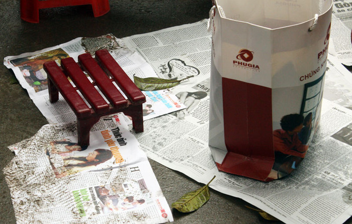 Người đến tham dự lễ cầu an thường mang theo báo để ngồi hoặc thuê ghế ở ngoài cổng chùa rồi đặt trước để giữ chỗ.