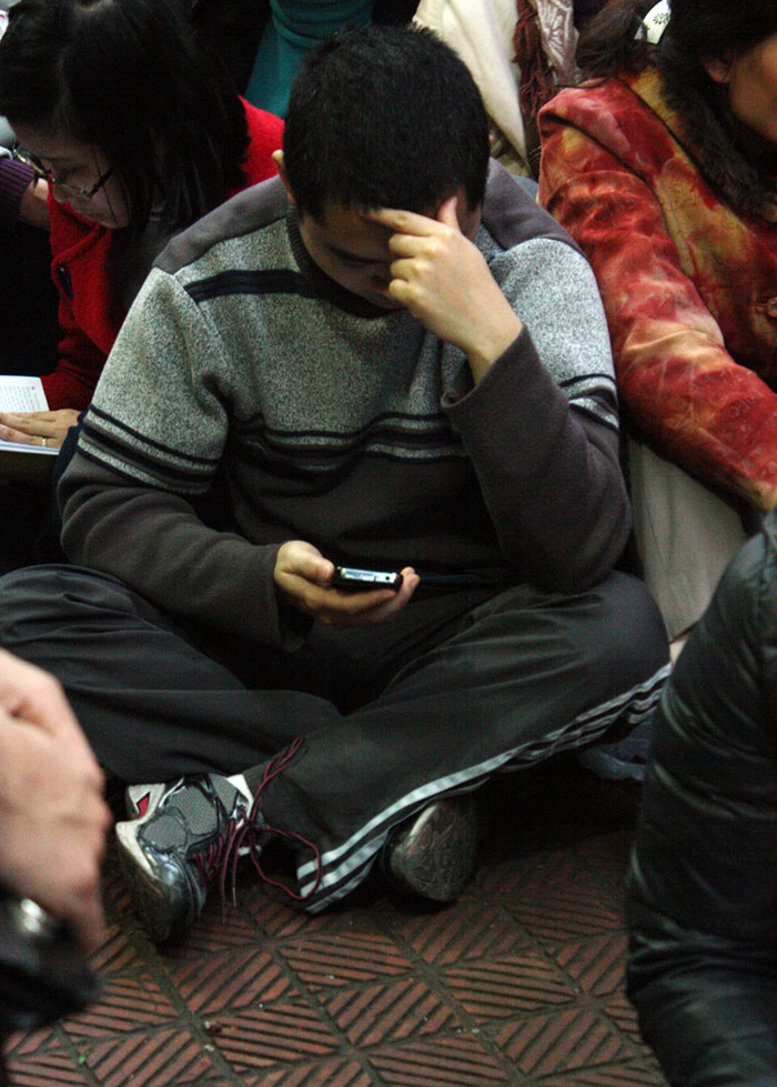 Các đấng mày râu thì tìm cách giết thời gian bằng cách đọc báo trên điện thoại di động.