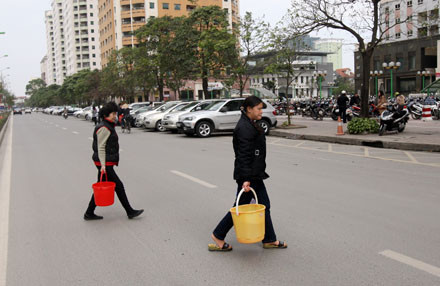 Người dân chung cư phải băng qua đường xách nước. May cho họ, những tòa nhà đối diện chưa có người ở nên vẫn còn chút nước để xin Người dân chung cư phải băng qua đường xách nước. May cho họ, những tòa nhà đối diện chưa có người ở nên vẫn còn chút nước để xin