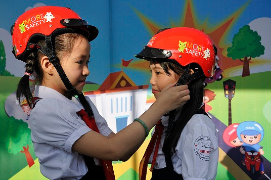 Các em học sinh tiểu học đội mũ bảo hiểm do YMVN trao tặng. Các em học sinh tiểu học đội mũ bảo hiểm do YMVN trao tặng.