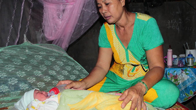 Bé gái đang được gia đình bà Công chăm sóc và nhận làm con nuôi - Ảnh: Tấn Đức