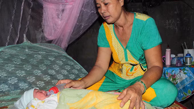 Bé gái đang được gia đình bà Công chăm sóc và nhận làm con nuôi - Ảnh: Tấn Đức