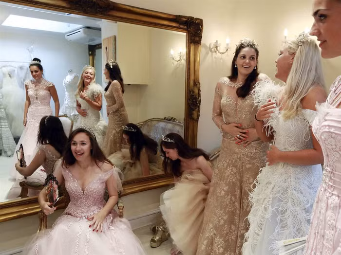 Từ trái qua phải Debutantes, Maria Austin, Amelia Simmons, Sophie Bonello, Zoe Rawson, và Georgina Riddle thử một chiếc váy phù hợp để dự buổi khiêu vũ Nữ hoàng Charlotte ở London, ngày 25 tháng 7, hình ảnh MSNBC nhận được ngày 26/9