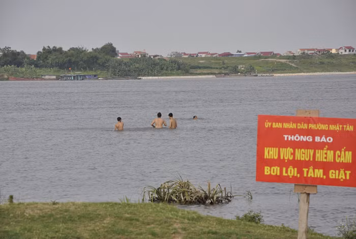 Biển cấm không phát huy được tác dụng khi nhiều người vẫn hồn nhiên bơi lội trên khu vực này.