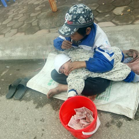 Trẻ ăn xin nằm hẳn giữa đường. (Ảnh Việt Báo) Trẻ ăn xin nằm hẳn giữa đường. (Ảnh Việt Báo)