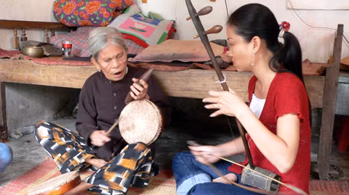 Bà Hà Thị Cầu đang “truyền nghề” cho một cô gái Hà Nội - Ảnh: Quốc Nam