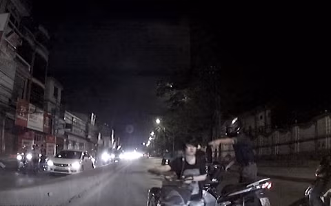 Thiếu nữ tỉnh bơ dắt xe bỏ đi sau khi gây tai nạn cho hai người. Ảnh: Vision