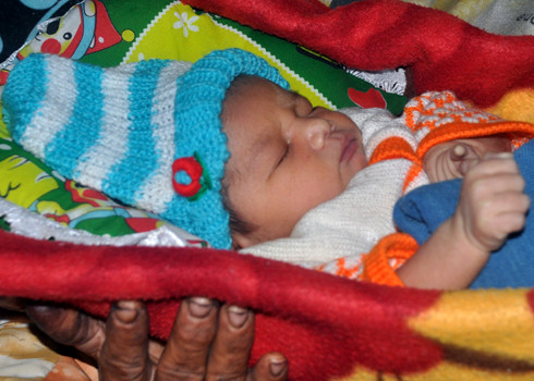 Hai bé sơ sinh trong vòng tay gia đình sau sự cố trao nhầm ảnh 7 Bé trai con của chị Hoái ngủ ngon lành trong vòng tay của bà Nội Đinh Thị Lạc trong căn bếp ấm áp ở nhà riêng tại xã Sơn Nham, huyện miền núi Sơn Hà. Sau sự cố trao nhầm trẻ sơ sinh, gia đình hai bên Nội, Ngoại cháu bé con chị Hoái đã thống nhất đặt tên cho cháu gắn với kỷ niệm "khôi hài" đầu đời là: Đinh Văn Đổi.