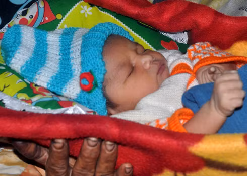 Bé trai con của chị Hoái ngủ ngon lành trong vòng tay của bà Nội Đinh Thị Lạc trong căn bếp ấm áp ở nhà riêng tại xã Sơn Nham, huyện miền núi Sơn Hà. Sau sự cố trao nhầm trẻ sơ sinh, gia đình hai bên Nội, Ngoại cháu bé con chị Hoái đã thống nhất đặt tên cho cháu gắn với kỷ niệm "khôi hài" đầu đời là: Đinh Văn Đổi.