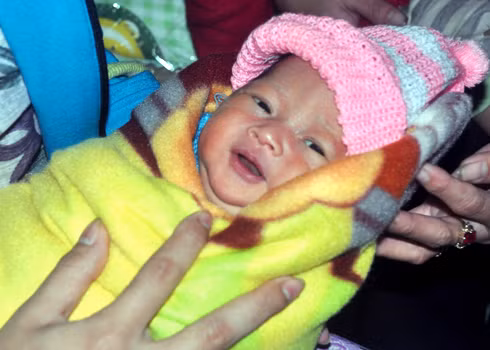 Bé gái con chị Cẩm kháu khỉnh mở mắt nhìn khách lạ đến thăm sáng nay.