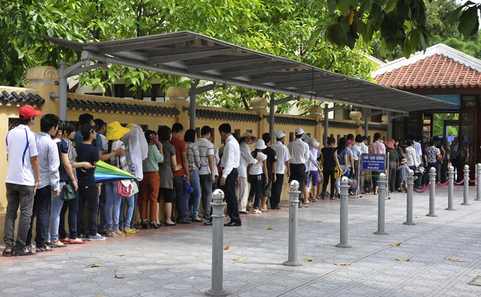 Người người xếp hàng đợi đi qua phòng an ninh.