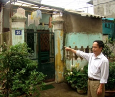 Anh Nguyễn Văn Lan đang đứng cạnh ngôi nhà xây trên diện tích đất nhà ông bị thu hồi.