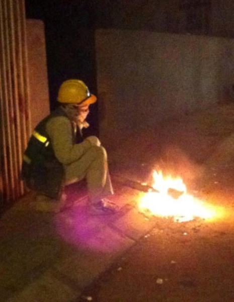 Hà Nội 9 độ C có mưa phùn..Người công nhân vệ sinh vẫn ngồi ven đường đốt từng thanh gỗ hay vụn giấy để sưởi ấm chờ xe đến lấy rác…Bức ảnh nhận được nhiều sự chia sẻ của cư dân mạng.