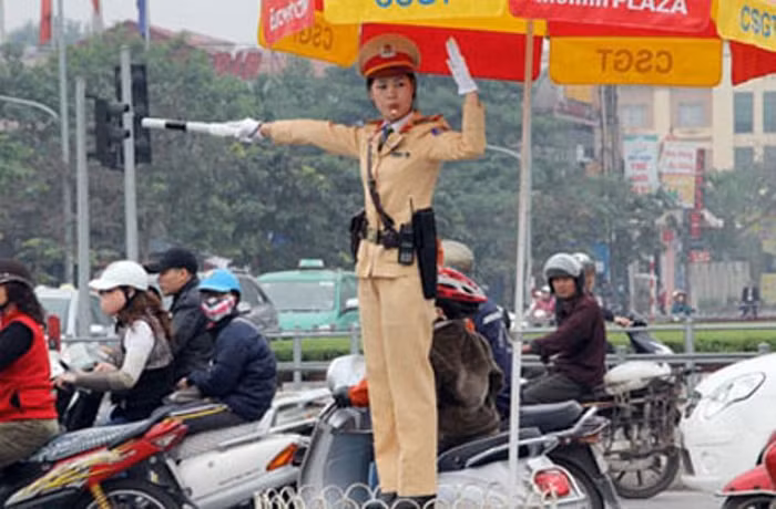Nữ cảnh sát giao thông đang điều khiển phương tiện lưu thông trên đường Nữ cảnh sát giao thông đang điều khiển phương tiện lưu thông trên đường