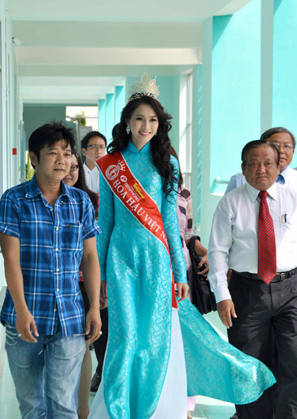Hoa hậu mặc áo dài màu xanh ngọc, đầu đội vương miện cao quý, môi luôn nở nụ cười tươi tắn. Hoa hậu mặc áo dài màu xanh ngọc, đầu đội vương miện cao quý, môi luôn nở nụ cười tươi tắn.