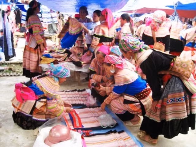 Người dân tộc Mông đi chợ mua vải về may quần áo