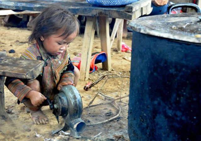 Tại chợ Cán Cấu (Bắc Hà, Lào Cai), một em bé ngồi quay bễ lò than tại một quán ăn Tại chợ Cán Cấu (Bắc Hà, Lào Cai), một em bé ngồi quay bễ lò than tại một quán ăn