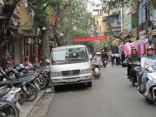 Xe máy để trên vỉa hè, ô tô đỗ dưới lòng đường ở phố Hàng Mã.