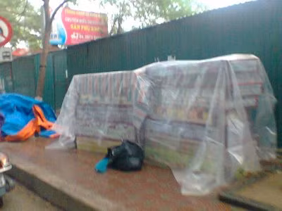 Các "cửa hàng" di động trên vỉa hè rất vất vả khi phải chạy mưa và trốn tránh lực lượng chức năng.