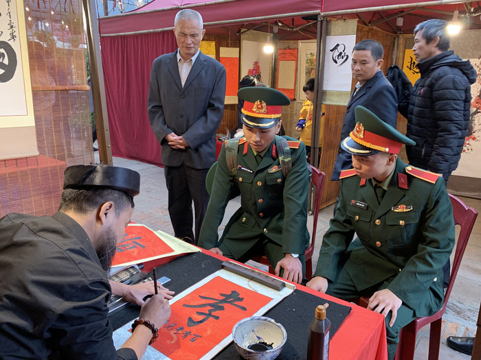 Hai sinh viên Quốc phòng trên đường về nhà ăn Tết cũng ghé qua Hội chữ xuân Canh Tý 2020 để xin chữ. Ảnh: Tùng Dương.