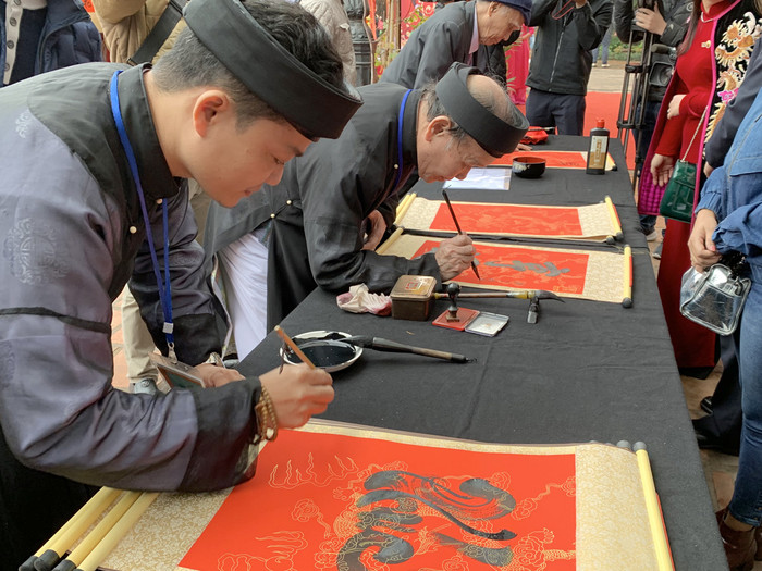Các ông đồ đang tặng chữ cho du khách tại Hội chữ xuân Canh Tý 2020. Ảnh: Tùng Dương.