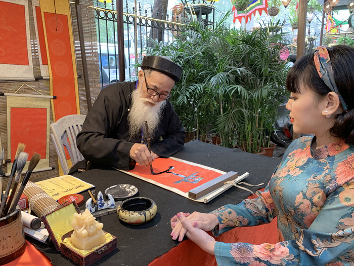 Khách đến tham quan Hội chữ xuân Canh Tý 2020 đang xin chữ ông đồ. Ảnh: Tùng Dương.