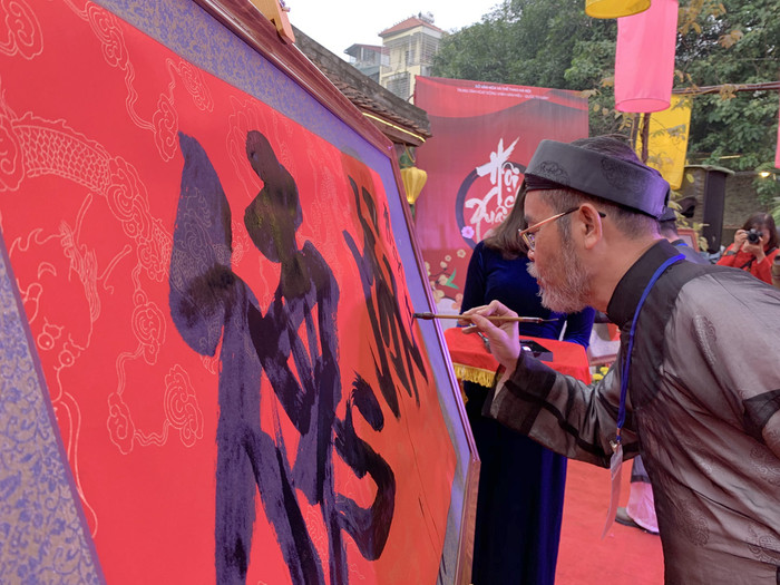 Nhà Thư pháp Nguyễn Đức Lợi đang trình diễn thư pháp tại Hội chữ xuân Canh Tý 2020. Ảnh: Tùng Dương.