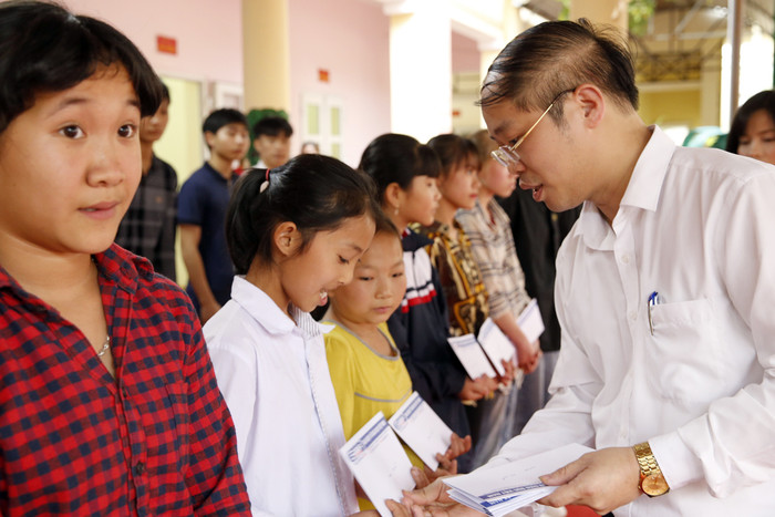 Ông Nguyễn Ánh Hoàng - Trưởng phòng Giáo dục và Đào tạo thị xã Phú Thọ, đang trao quà cho các em học sinh có hoàn cảnh khó khăn. Ảnh: Tùng Dương.