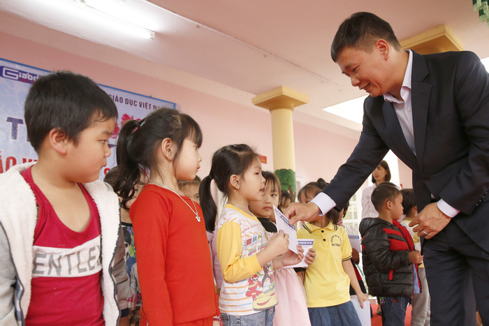 Nhà báo Nguyễn Tiến Bình - Tổng biên tập Báo điện tử Giáo dục Việt Nam, trao quà Tết cho học sinh có hoàn cảnh khó khăn. Ảnh: Tùng Dương.