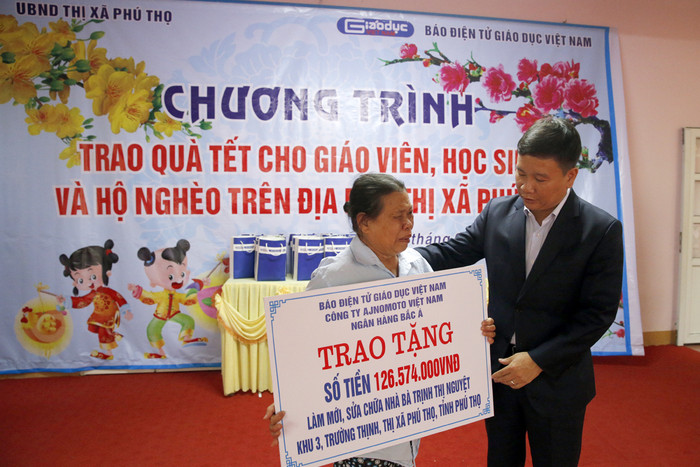 Nhà báo Nguyễn Tiến Bình - Tổng biên tập Báo điện tử Giáo dục Việt Nam trao tặng số tiền để làm mới và sửa chữa căn nhà cho bà Trịnh Thị Nguyệt 67 tuổi. Ảnh: Tùng Dương.