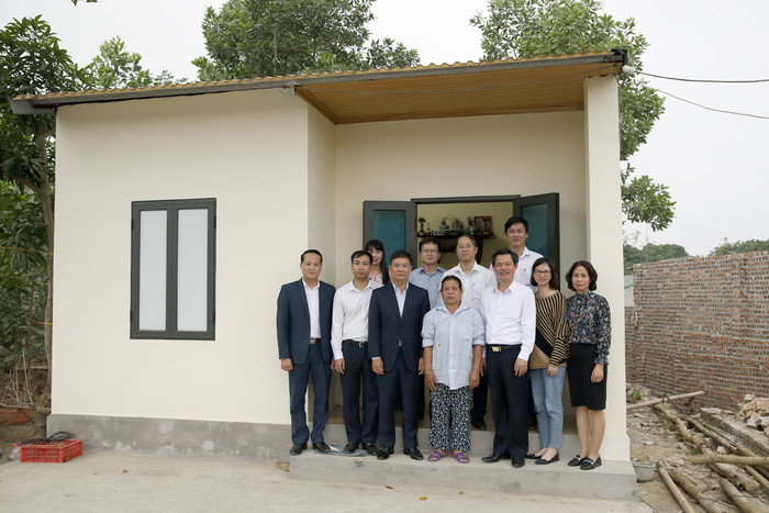 Bà Trịnh Thị Nguyệt chụp ảnh lưu niệm trước căn nhà mới của mình cùng với Tổng biên tập Báo điện tử Giáo dục Việt Nam và các lãnh đạo Ủy ban nhân dân thị xã Phú Thọ. Ảnh: Tùng Dương.