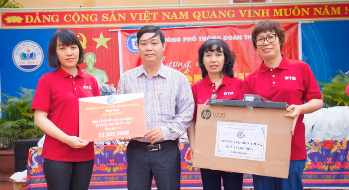 Nhà giáo Vũ Anh Tú - Phó hiệu trưởng Trường Trung học phổ thông Đoàn Thị Điểm (ngoài cùng bên trái ảnh), đại diện cho ban giám hiệu nhà trường trao quà tại xã Lộc Thủy, tỉnh Quảng bình. Ảnh: Hữu Thành.