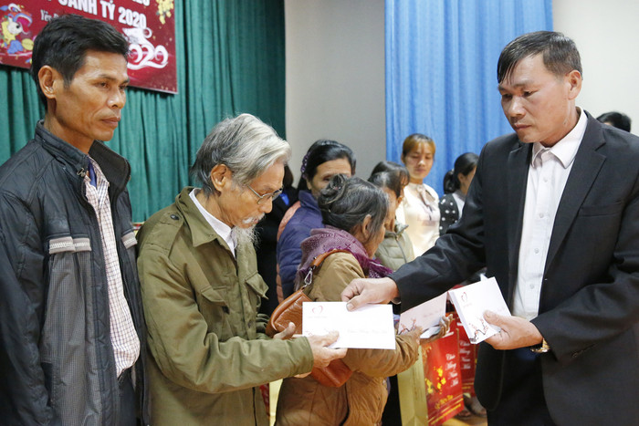 Ông Nguyễn Xuân Tú - Chủ tịch Ủy ban nhân dân xã Yên Dưỡng, trao quà Tết cho các hộ có hoàn cảnh khó khăn trong xã. Ảnh: Tùng Dương.