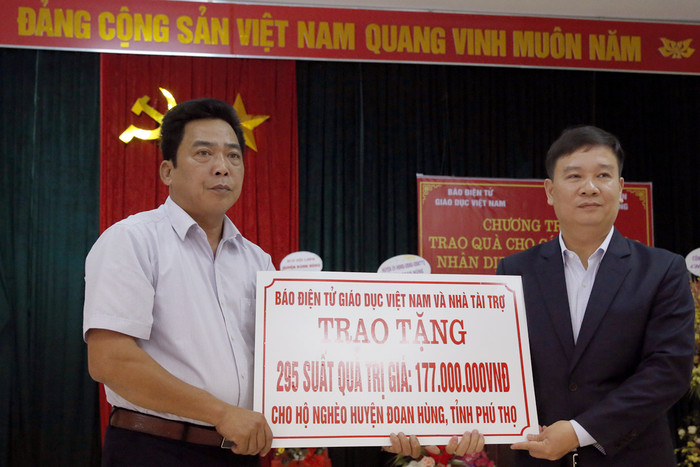 Nhà báo Nguyễn Tiến Bình - Tổng biên tập Báo điện tử Giáo dục Việt Nam (người đứng bên phải ảnh) và đồng chí Nguyễn Khắc Trung - phó Chủ tịch Ủy ban nhân dân xã Phú Lâm trong buổi lễ trao quà Tết. Ảnh: Tùng Dương.