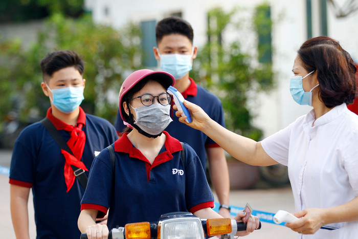Nhà trường tiến hành đo thân nhiệt học sinh trước khi vào trường. Ảnh: Tùng Dương. Nhà trường tiến hành đo thân nhiệt học sinh trước khi vào trường. Ảnh: Tùng Dương.