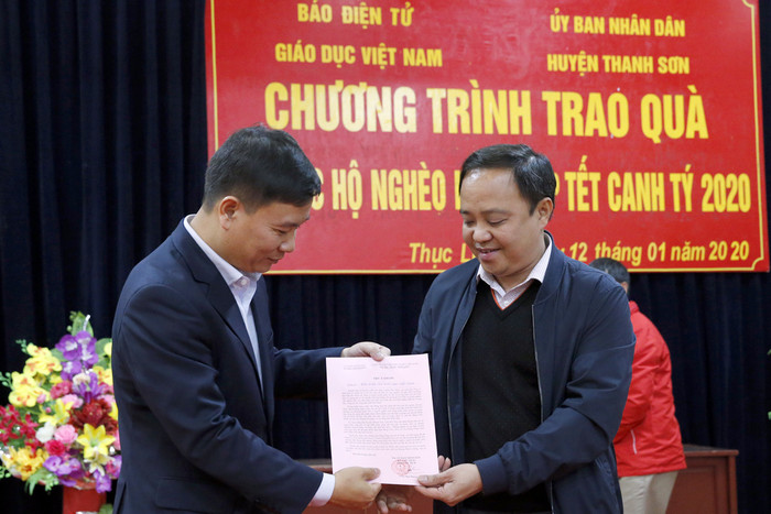 Nhà báo Nguyễn Tiến Bình - Tổng biên tập Báo điện tử Giáo dục Việt Nam (người bên trái ) đang nhận thư cảm ơn từ ông Vũ Anh Tuấn - Bí thư Đảng ủy xã Thục Luyện. Ảnh: Tùng Dương.