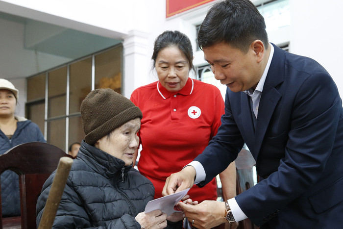 Nhà báo Nguyễn Tiến Bình - Tổng biên tập Báo điện tử Giáo dục Việt Nam đang trao quà Tết cho cụ bà Đỗ Thị Thúy 78 tuổi ở thị trấn Thanh Sơn. Ảnh: Tùng Dương.