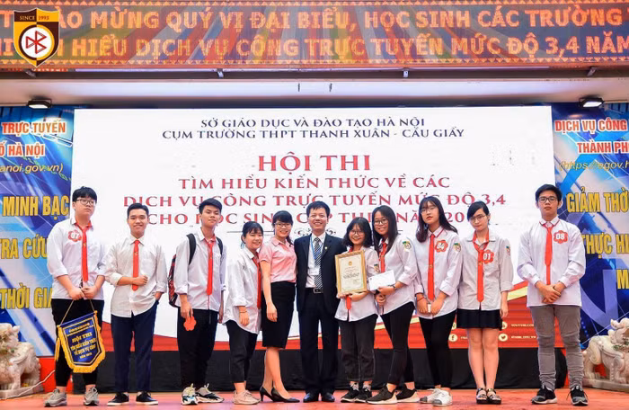 Thầy Đàm Tiến Nam - Hiệu trưởng Trường Trung học cơ sở, Trung học phổ thông Nguyễn Bỉnh Khiêm (người đứng giữa ảnh) và cô giáo Trang cùng các em học sinh của nhà trường. Ảnh: NVCC.