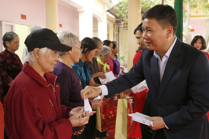 Nhà báo Nguyễn Tiến Bình - Tổng biên tập Báo điện tử Giáo dục Việt Nam, gửi quà và lời chúc sức khỏe đến các hộ nghèo trong thị xã Phú Thọ. Ảnh: Tùng Dương.