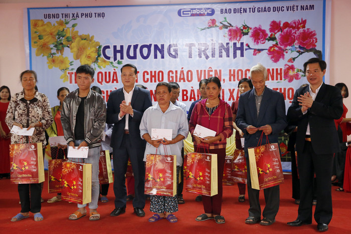 Ông Nguyễn Công Huân - phó Chủ tịch Ủy ban nhân dân thị xã Phú Thọ và Tiến sĩ Trịnh Thế Truyền - Giám đốc Sở Giáo dục và Đào tạo tỉnh Phú Thọ, đang trao quà cho các hộ nghèo. Ảnh: Tùng Dương.